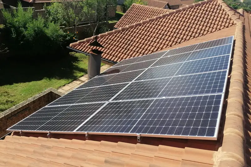 Panneaux solaires sur un toit de tuiles rouges.